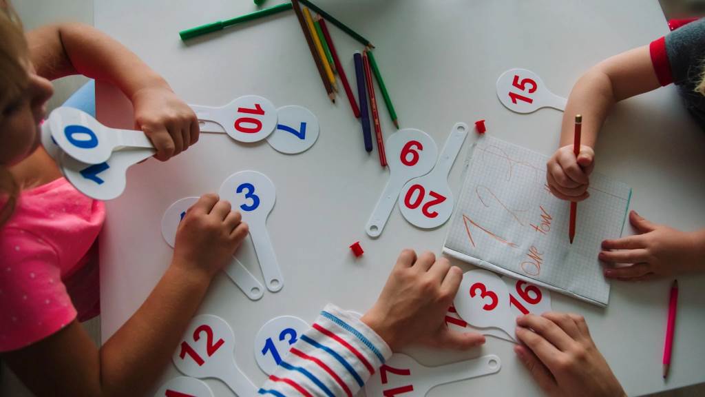 Cupcake tin filled with pom-poms for a hands-on preschool math counting game